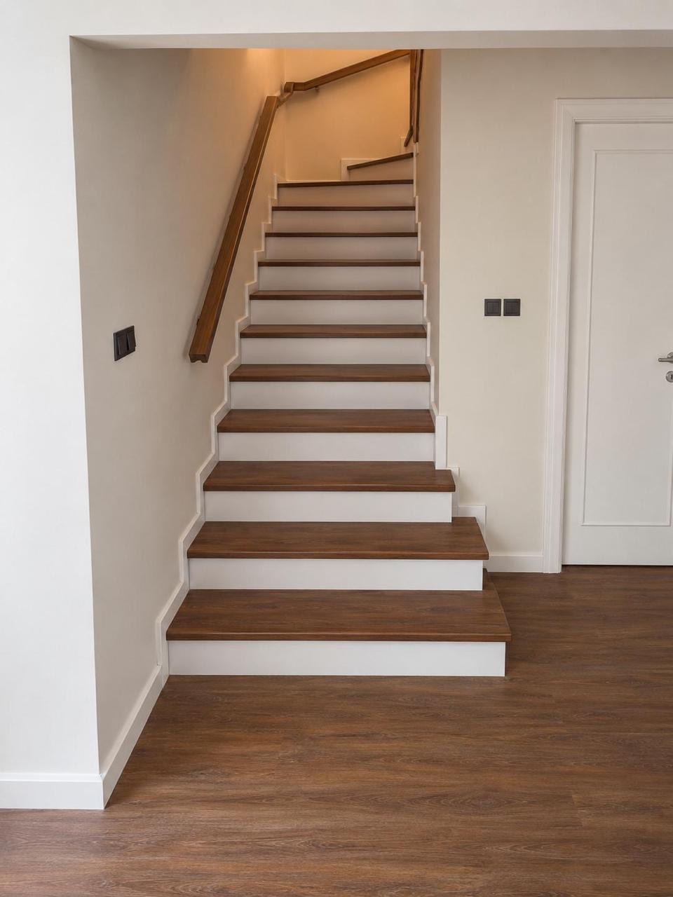 Staircase after renovation: painted risers and oak treads with a timber handrail.